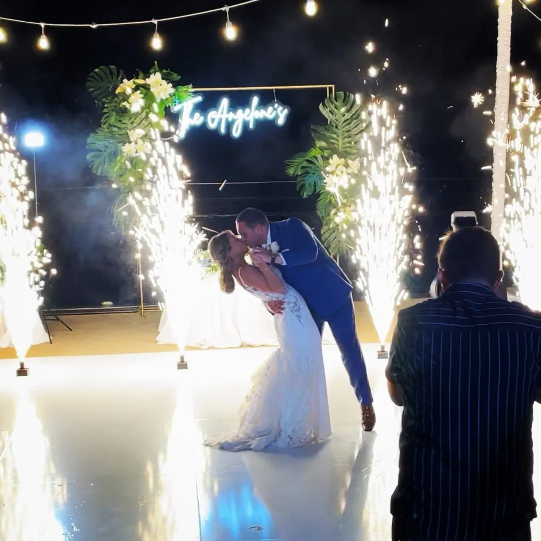 A wedding couple kissing in front of cold spark cannons