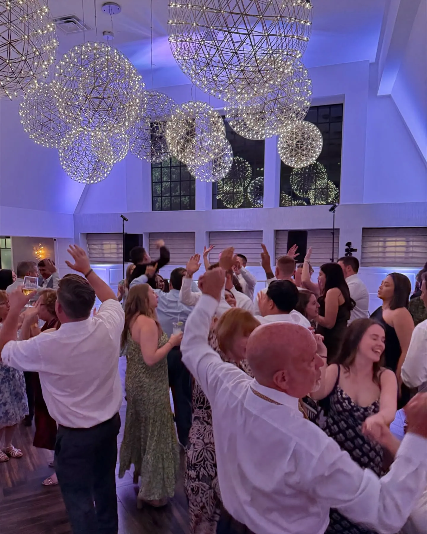 A crowd of people dancing at a wedding