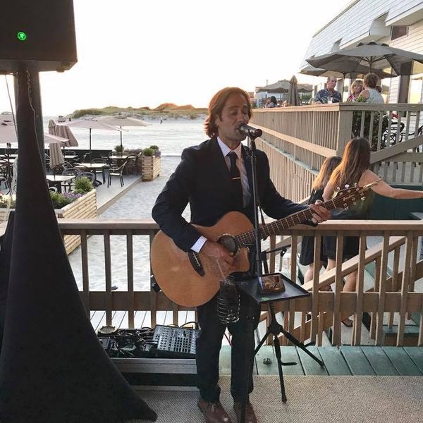 An acoustic performer during a cocktail hour
